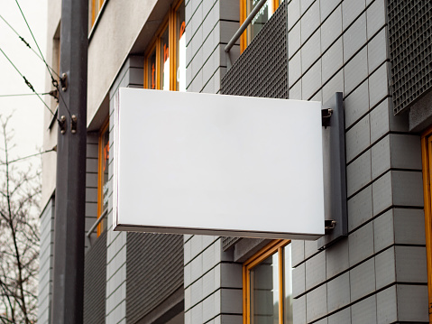 Empty display on a facade of a business inside the building. Template for testing a logo or a sign next to a wall. Blank mockup to advertise a brand. Signboard of a cafe a restaurant or an office.