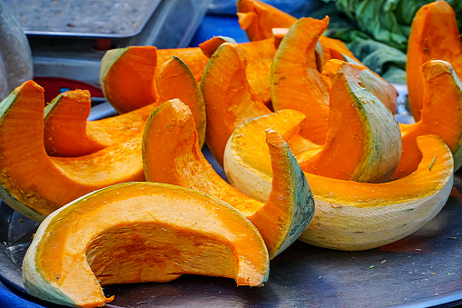 Fresh organic pumpkin slices on the market stall. Fresh pumpkin from farm. Pumpkin season.
