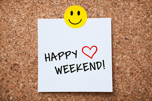 White Sticky Note With Happy Weekend And Red Push Pin On Cork Board
