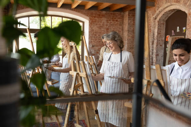 Happy old woman enjoying creative art group lesson.