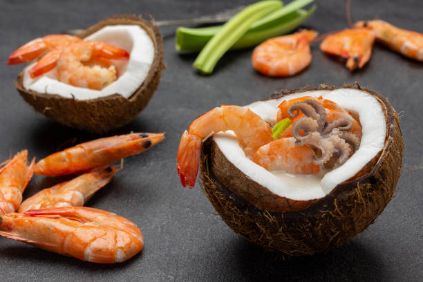 istock Seafood cream soup in coconut. Shrimps and leeks on table. 1371798163