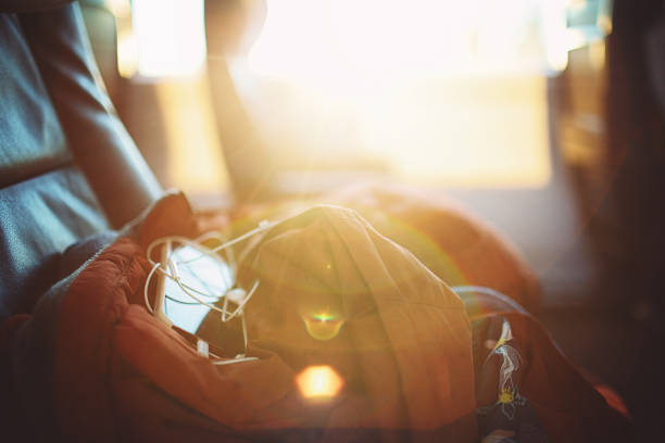 A jacket and a cell phone lie on the seat in the train during sunset.