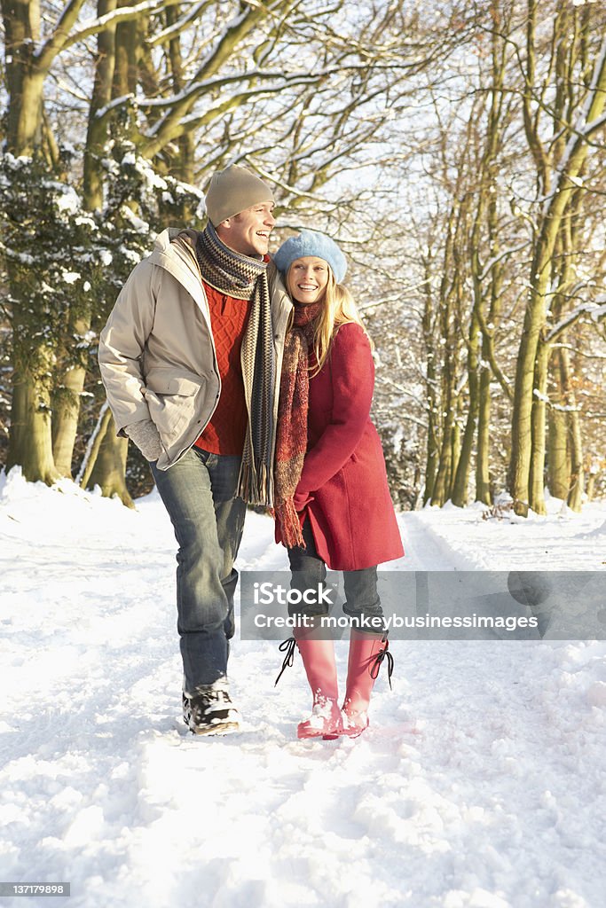 Couple Walking Through Snowy Woodland Couple Walking Through Snowy Woodland Laughing Together Winter Stock Photo
