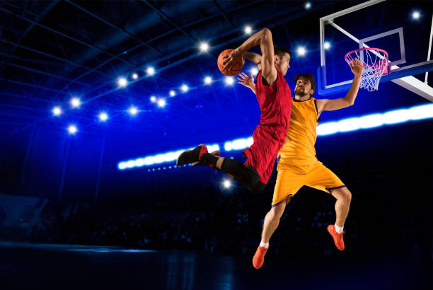 Two basketball player players in action on dark background