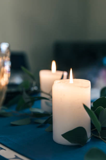 Close-up, burning candles on the table among the leaves.