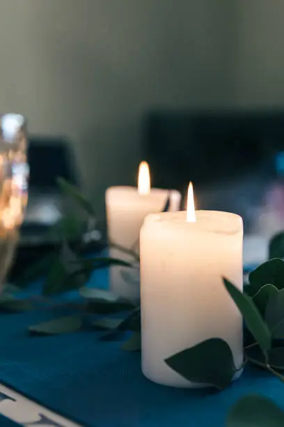 Photo of Close-up, burning candles on the table among the leaves.