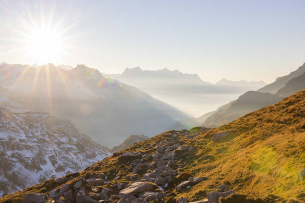 paesaggio incredibile nel cuore della svizzera. scenario epico con le nuvole e la nebbia. meravigliosi raggi di sole attraverso le nuvole e più tardi un tramonto e un'alba incredibili. viaggio perfetto attraverso la svizzera. - sunrise european alps mountain alpenglow foto e immagini stock