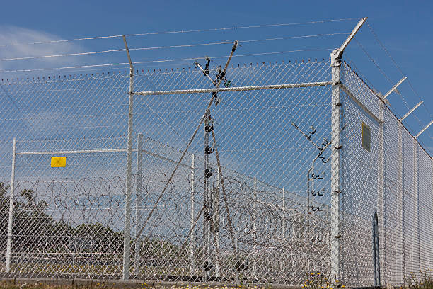 Razor wire and fence in sun - Nuclear fuel reprocessing plant in La Hague, Basse Normandy, France, Europe
