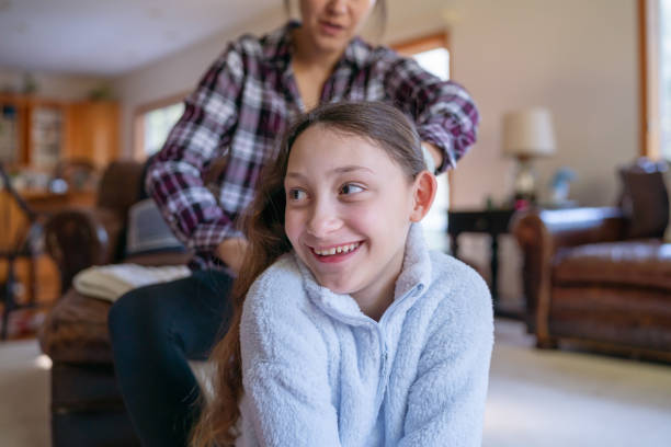 istock Tween girl having her hair done by her mom 1371805307