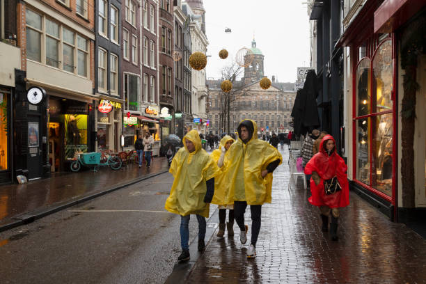 Amsterdam, Netherlands, February 20, 2022; Tourists walk through the rain in Amsterdam.