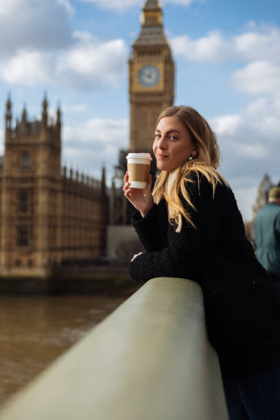 istock Young woman drinking coffee in a disposable cup on Westminster Bridge 1371809946