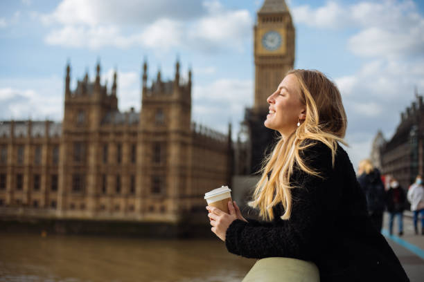 istock Young woman drinking coffee in a disposable cup on Westminster Bridge 1371809983