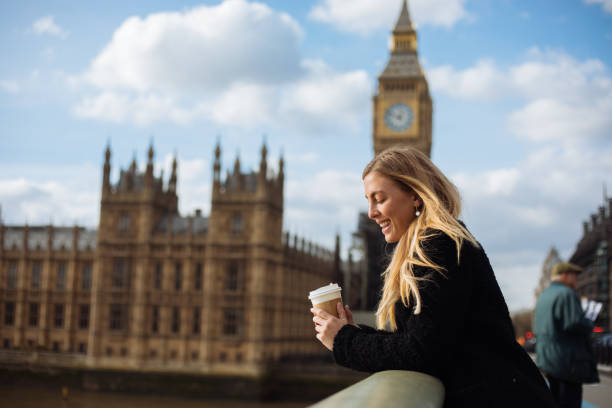 istock Young woman drinking coffee in a disposable cup on Westminster Bridge 1371810017