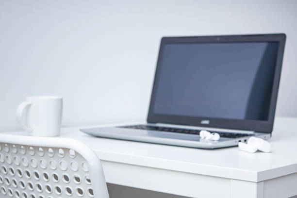 istock Laptop, white cup, wireless headphones on a white table. Workplace. 1371810408