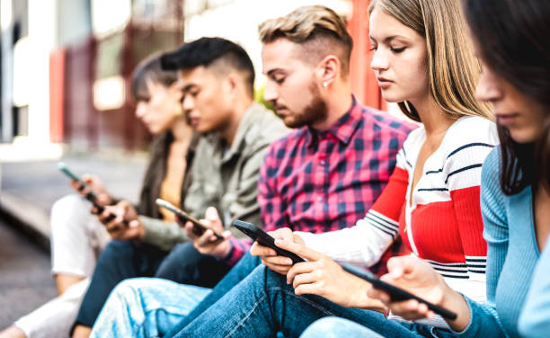 istock Bored friends group using smartphone sitting at university college backyard - Young people addicted by mobile smart phone - Technology sad life concept with always connected students - Contrast filter 1371810447