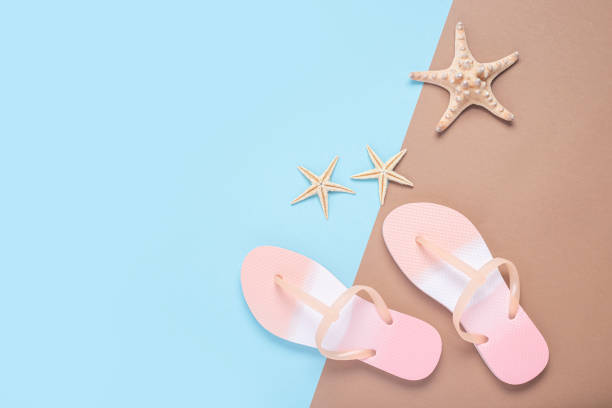 istock Flip flops and starfishes on a brown-blue background. Top view, flat lay. 1371811500