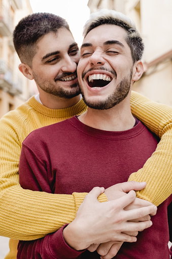 Gay male couple having tender moment outdoor in the city - LGBT love concept - Focus on right face