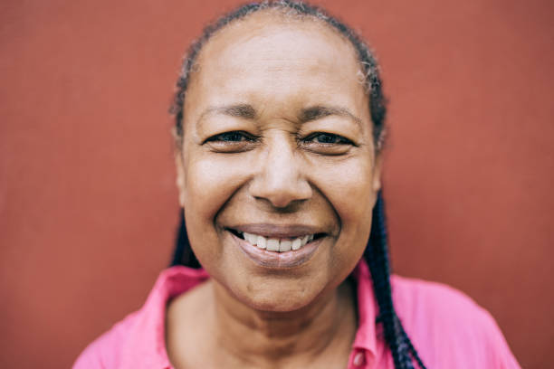 happy senior african woman posing and smiling on camera outdoor - real people, diversity and elderly concept - focus on eyes - life events laughing women latin american and hispanic ethnicity imagens e fotografias de stock