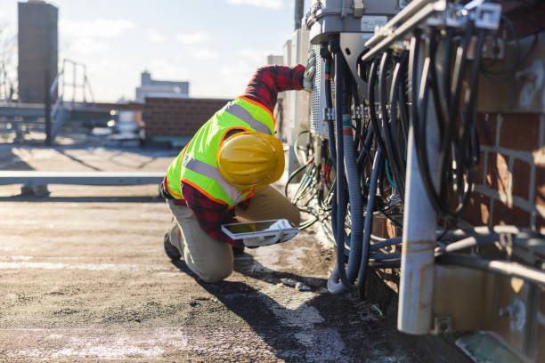 istock A blue-collar worker, a repairman, is checking and servicing telecommunication equipment mounted on a rooftop. 1371815085