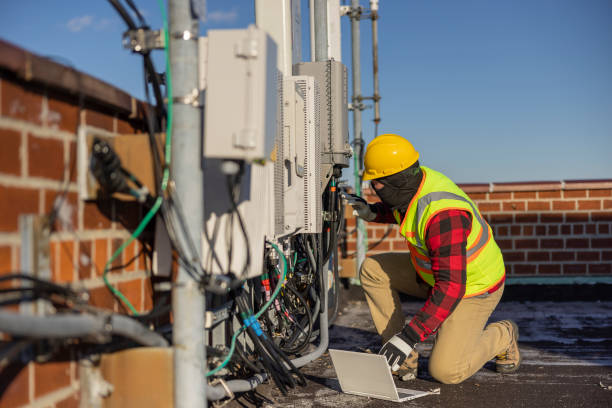 istock A blue-collar worker, a repairman, is checking and servicing telecommunication equipment mounted on a rooftop. 1371815094