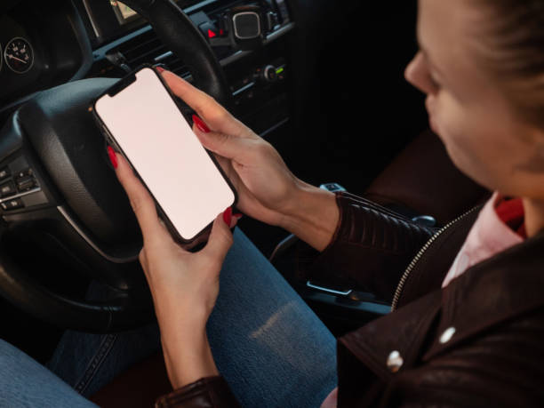 istock Woman using a blank screen smart phone on a car 1371815938