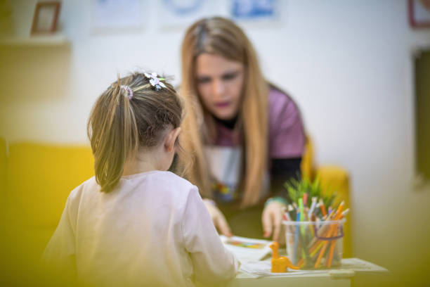 l’éducateur travaille avec un petit enfant dans un atelier pour enfants - enfant à la garderie photos et images de collection