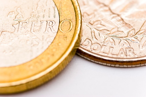Extreme close up of a one euro coin and a quarter dollar coin. This image is part of a money concepts series.