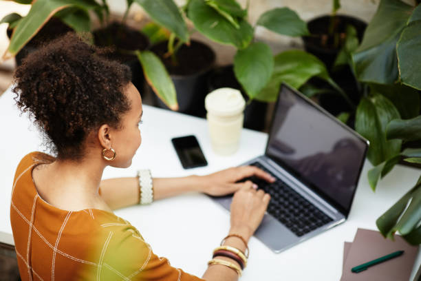 istock Young African American woman looking at laptop screen while typing on keyboard 1371820399