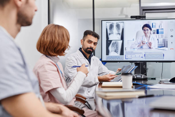 istock Confident mature chief physician interacting with nurse by workplace 1371822419