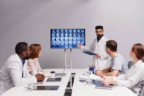 oncólogo confiado que hace una presentación de la resonancia magnética del paciente a sus colegas - exam business caucasian board room fotografías e imágenes de stock