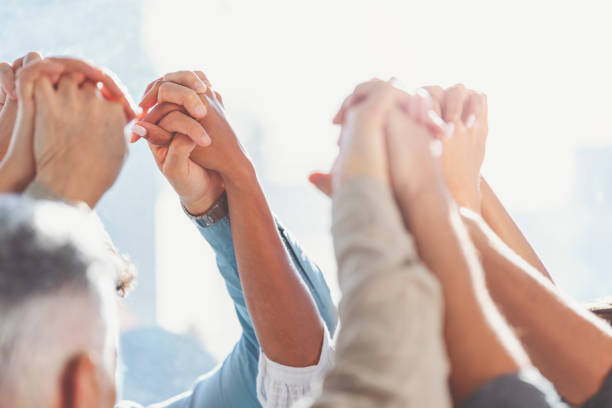 istock Group of workers holding hands in celebration. 1371824944