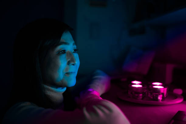 istock Mature woman looking at computer screen at home at night 1371825462