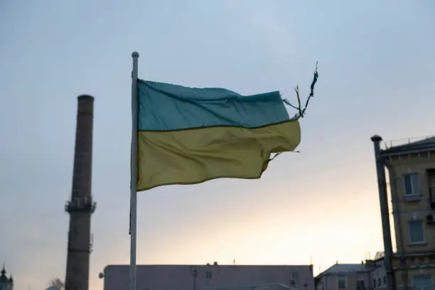 A weathered Ukrainian flag flies in the Podil district of Kyiv, Ukraine