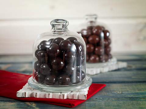 Chocolate drops inside a jar on a table top