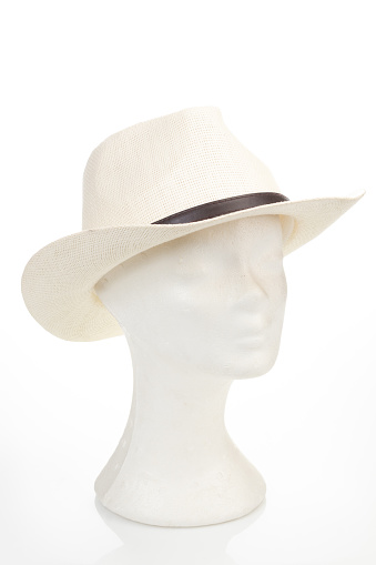 Mannequin head wearing straw hat isolated on white background, side headshot