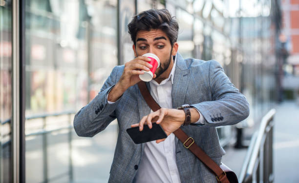 never don't be late on business meeting. worried businessman looking at his watch on the way to office. business, lifestyle concept - urgent imagens e fotografias de stock