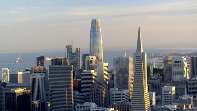 Sweeping Aerial view of the Skyline downtown San Francisco with the TransAmerica Pyramid as tankers sit in the Bay