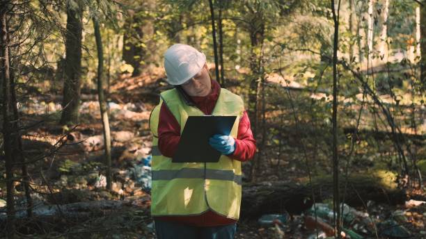 istock Ecologist woman in workwear issues fine for dumping plastic waste in park 1371841933
