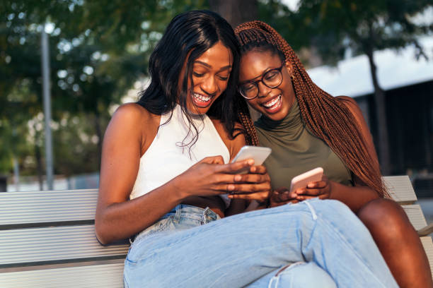 istock two young women laughing looking social networks 1371842547