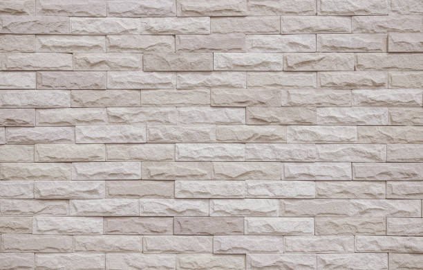 istock Cream and beige brick wall texture background. Brickwork and stonework flooring interior rock old pattern clean concrete grid uneven bricks office design. Background of old vintage brick wall backdrop 1371849249