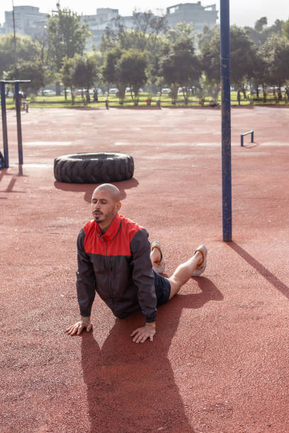 istock Vertical shot of a bald man doing cobra stretch in a park 1371853437