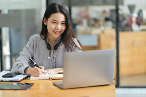 istock Beautiful Young Freelancer Woman Using Laptop Computer Sitting At Cafe Table. Happy Smiling Girl Working Online Or Studying And Learning While Using Notebook. Freelance Work, Business People Concept 1371857527
