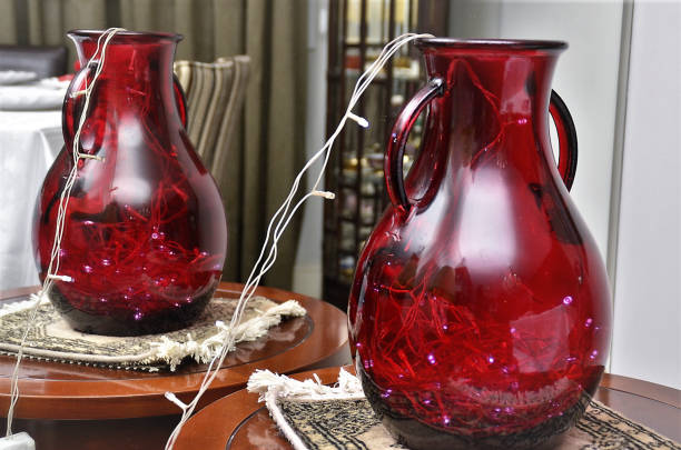 A Christmas decoration with a red glass jug with LED light inside
