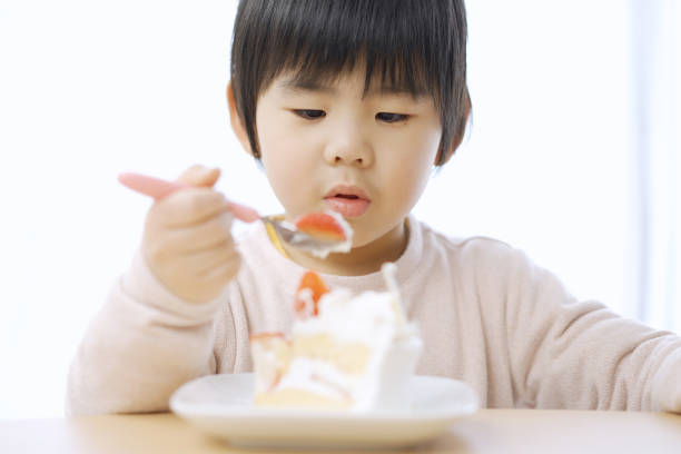 istock Asian boy eating birthday cake 1371859693