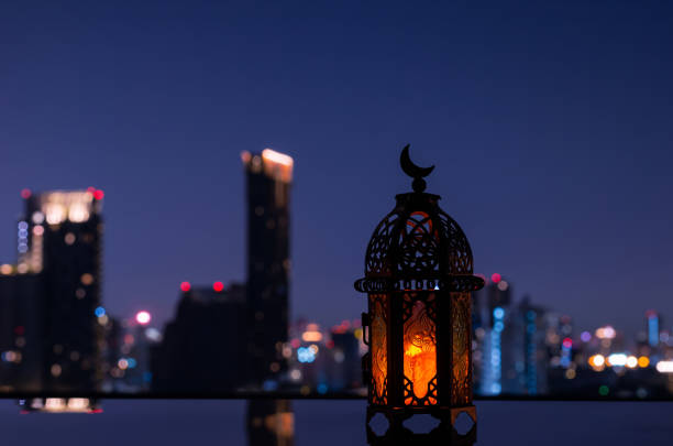 istock Lantern that have moon symbol on top with night city background 1371859928