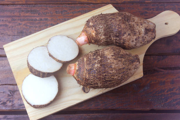 ñame crudo sobre mesa de madera rústica. también conocido como alocasia, colocasia, xanthosoma - ñame fotografías e imágenes de stock