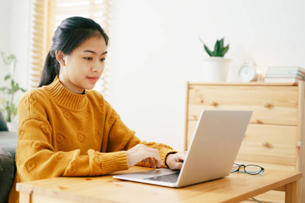 istock Beautiful Asian woman using a laptop computer 1371867804