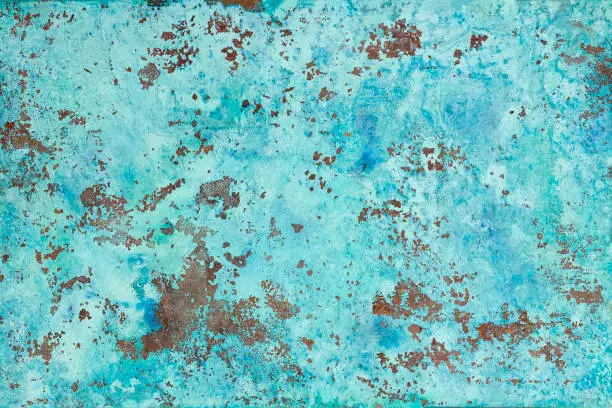 Photo of Abstract old worn, weathered and peeling oxidized copper metal surface.