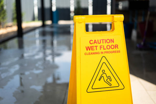"Caution, Wet floor" with slip icon, a safety information sign. "Caution, Wet floor" with slip icon, a safety information sign which is placed in front of toilet during cleaning is in progress. Close-up and selective focus. greasy water stock pictures, royalty-free photos & images
