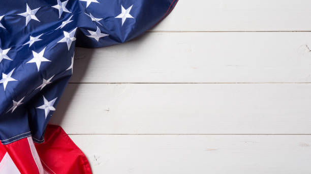 istock American flag lying on old white wooden background 1371872132